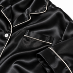 Close-up of black mulberry silk fabric showing its sheen and drape.